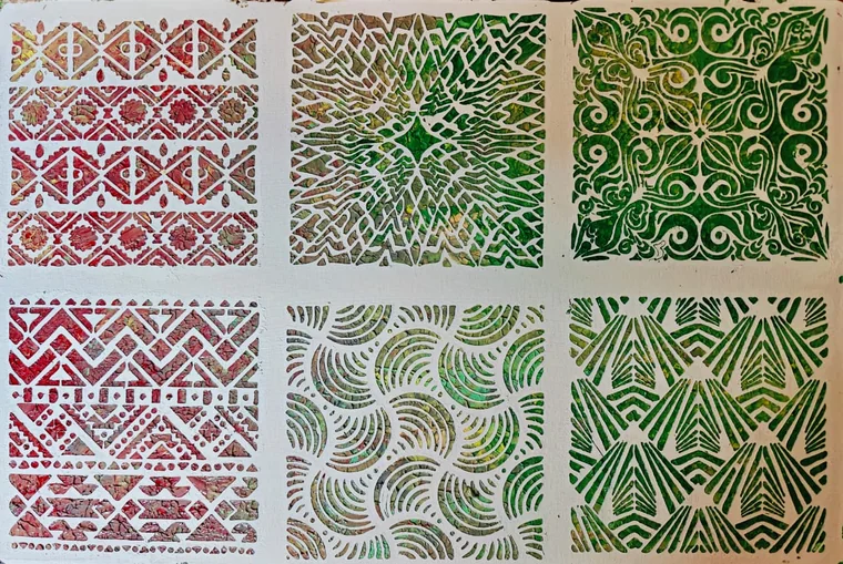 A sheet of six stencilled pattern squares: tribal bands and chevrons in red, a lattice and fans in olive, scrollwork and waves in green, on white.