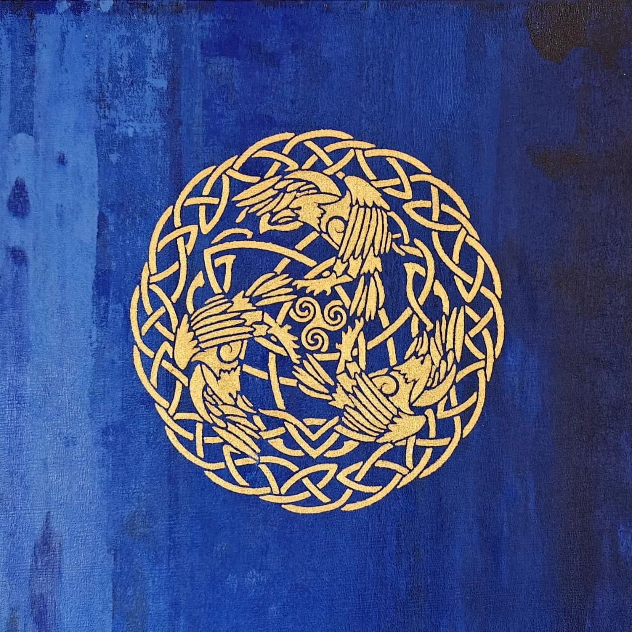 A gold Celtic knotwork roundel of three interlaced cranes around a central triple spiral, on a deep blue ground.